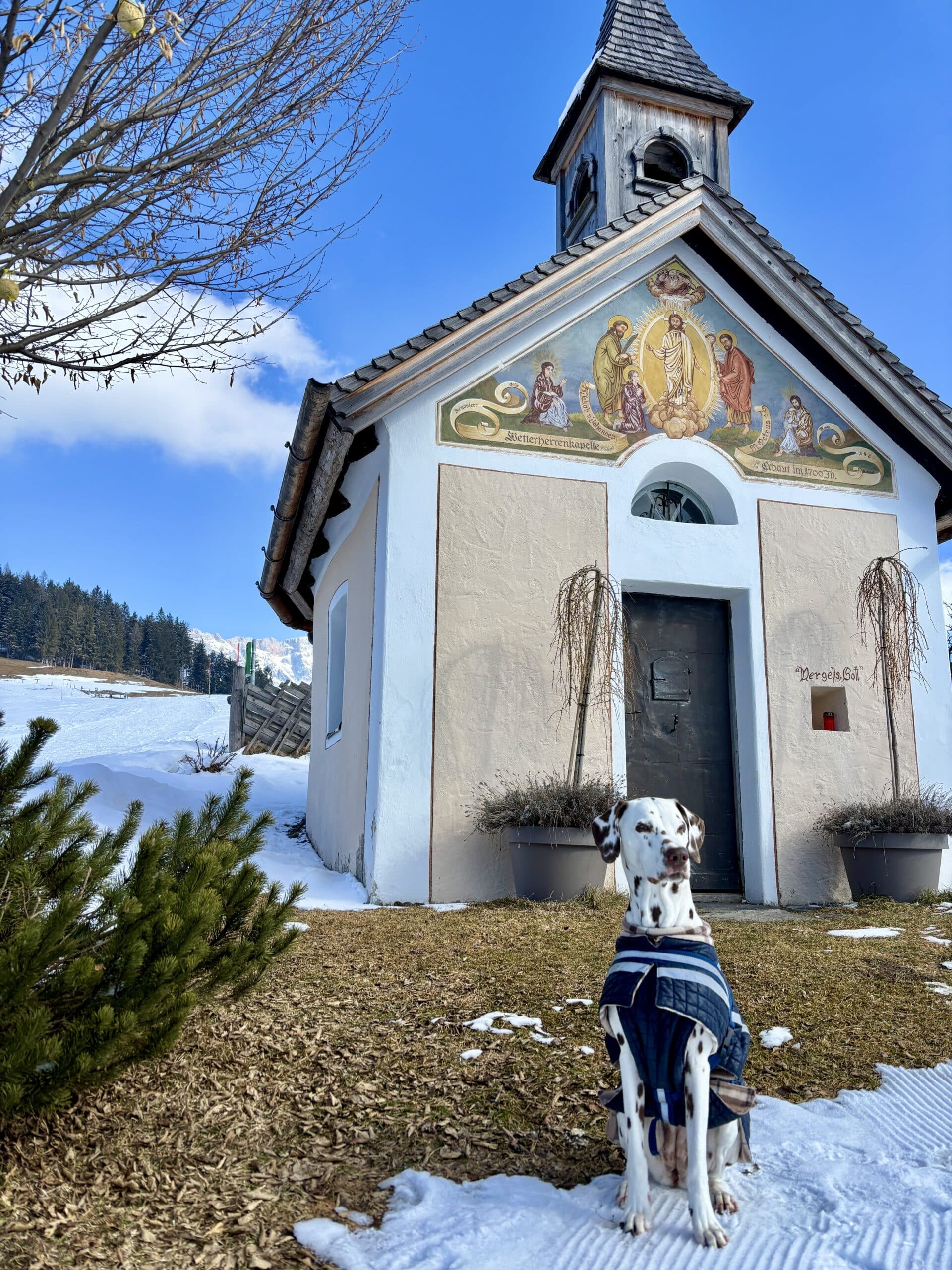 Hund sitzt vor Kapelle