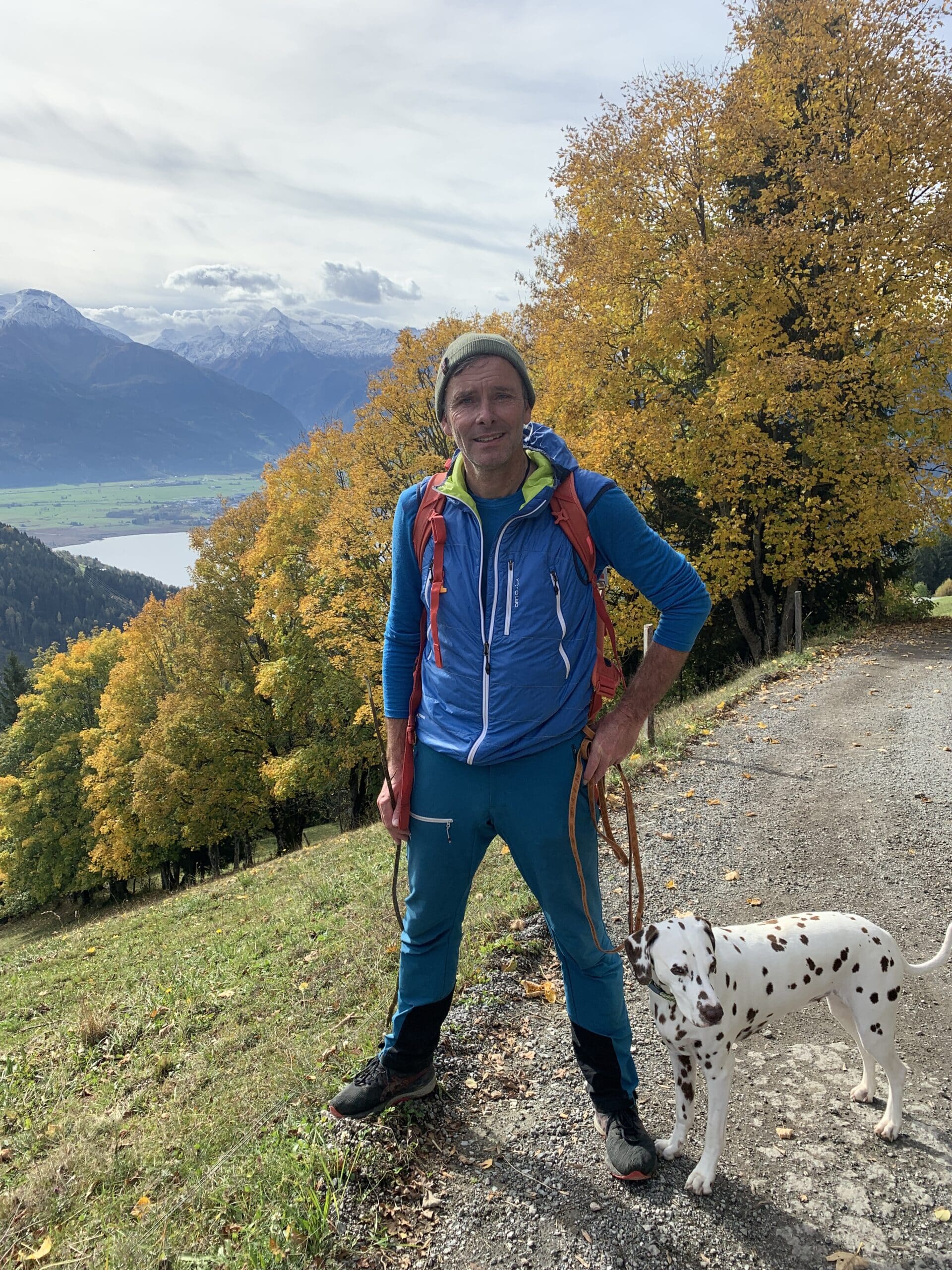 Mann mit Hund im Herbst beim Wandern