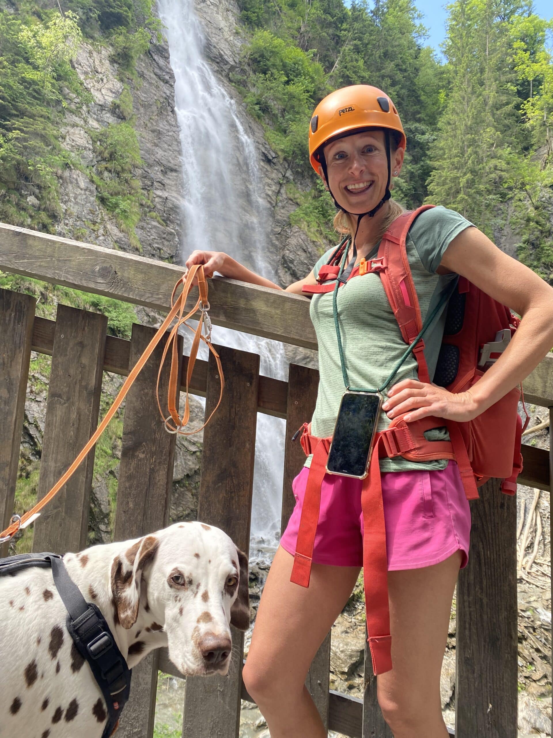 Frau mit Hund in Klamm vor Wasserfall
