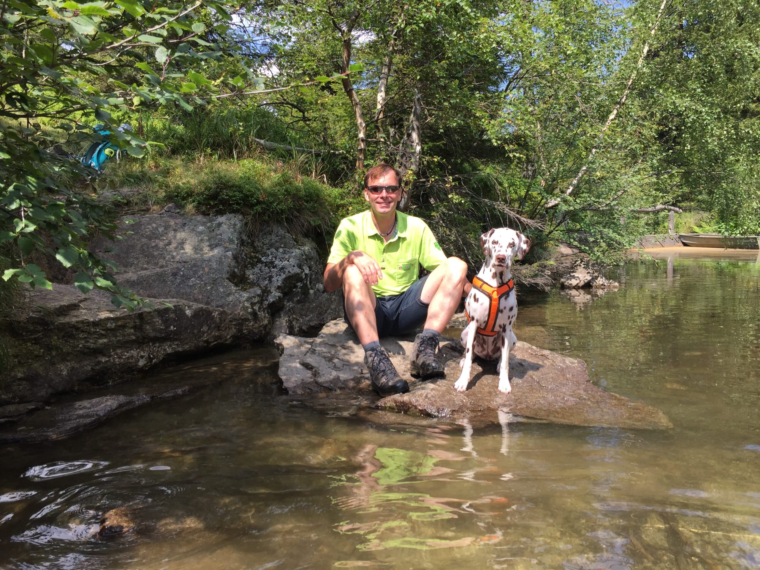 Mann sitzt mit Dalmatiner Hund am Hüttensee bei Hans Wödl Hütte, Bergsee