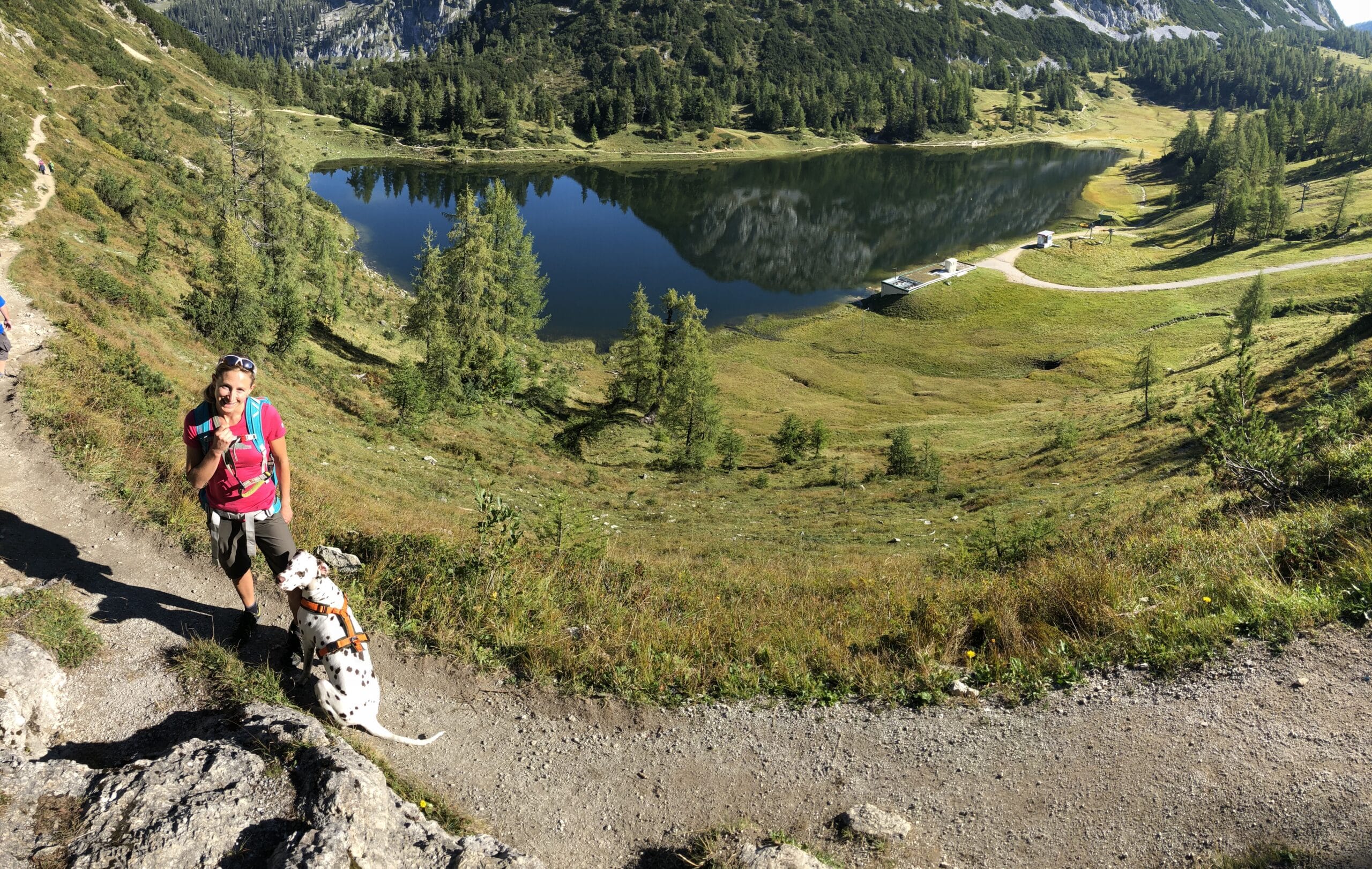 Frau wandert mit Hund oberhalb vom Steirersee auf Tauplitz