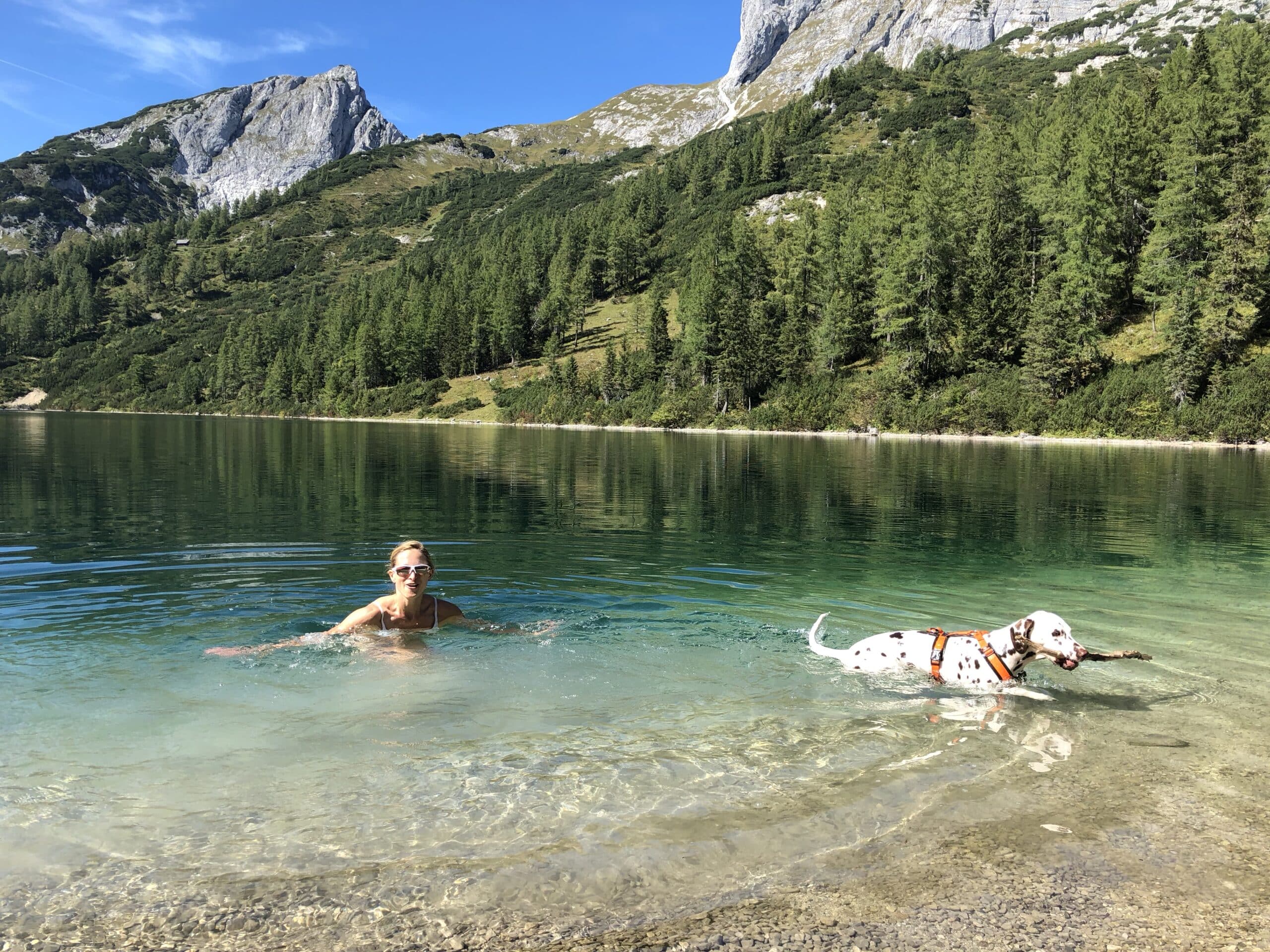 Frau schwimmt mit Hund im Steirersee auf der Tauplitz