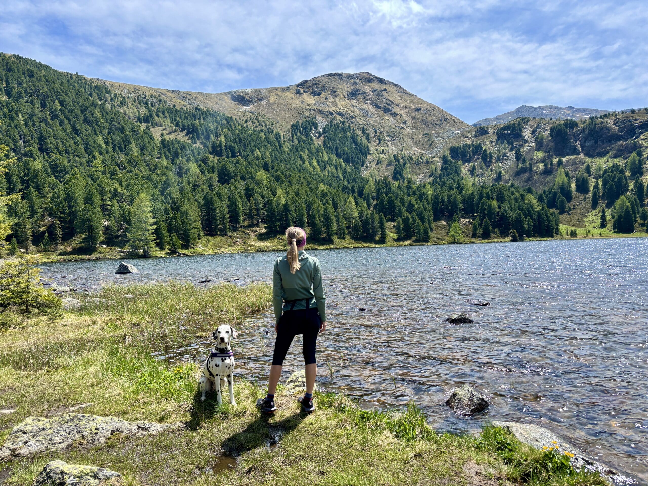 Frau steht mit Hund am Großen Winterleitensee