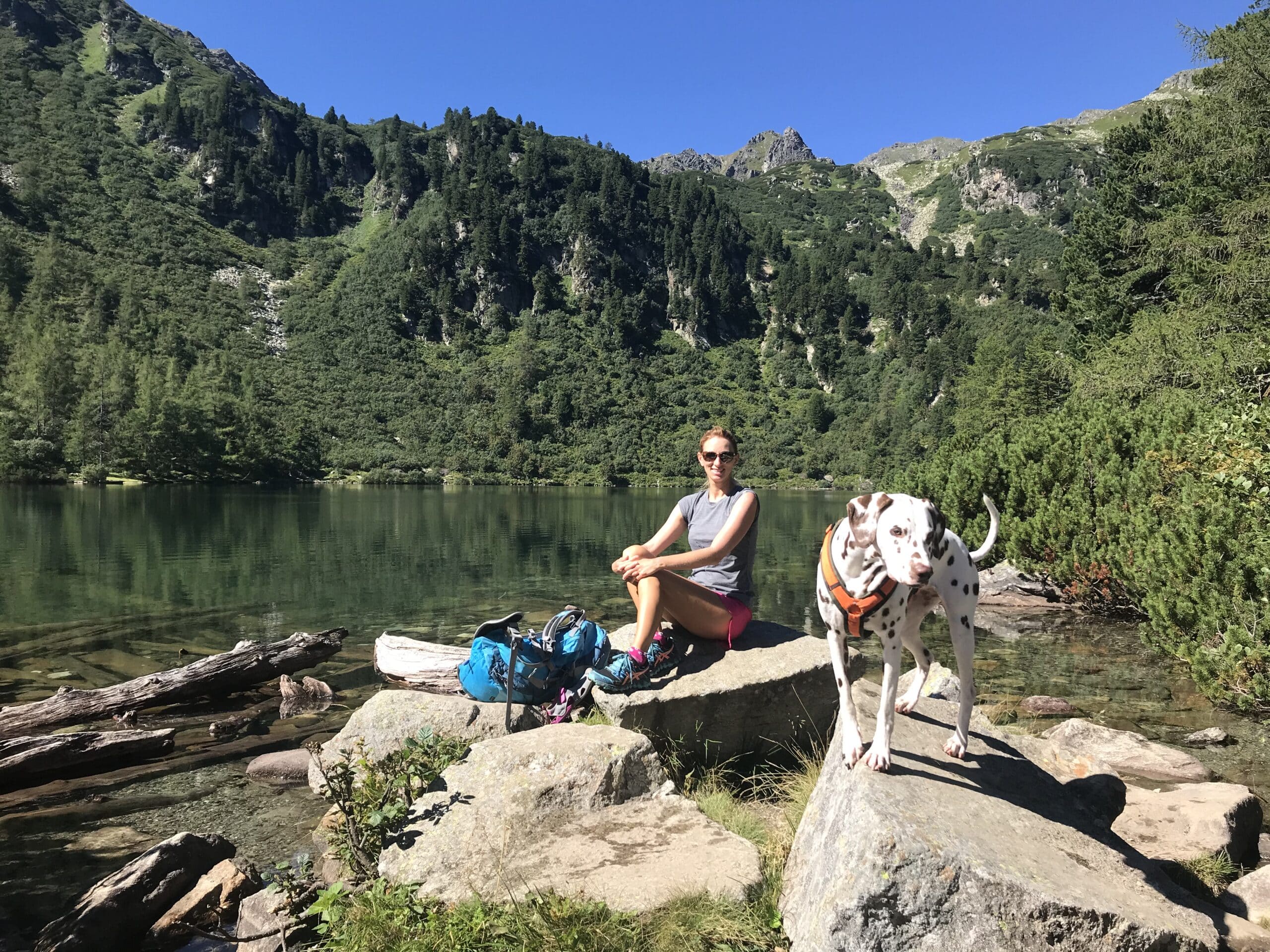 Frau sitzt auf Felsen mit Hund am Großen Scheibel See in Hohentauern