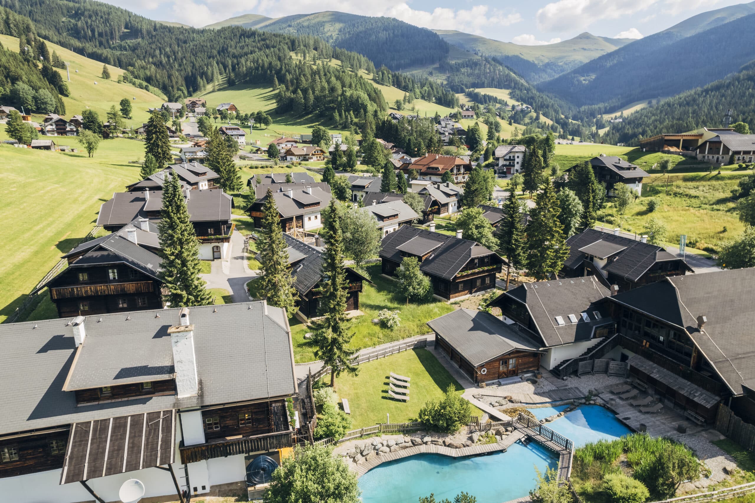 Slow Travel Resort Kirchleitn Vogelperspektive mit Ferienhäuser und Pools