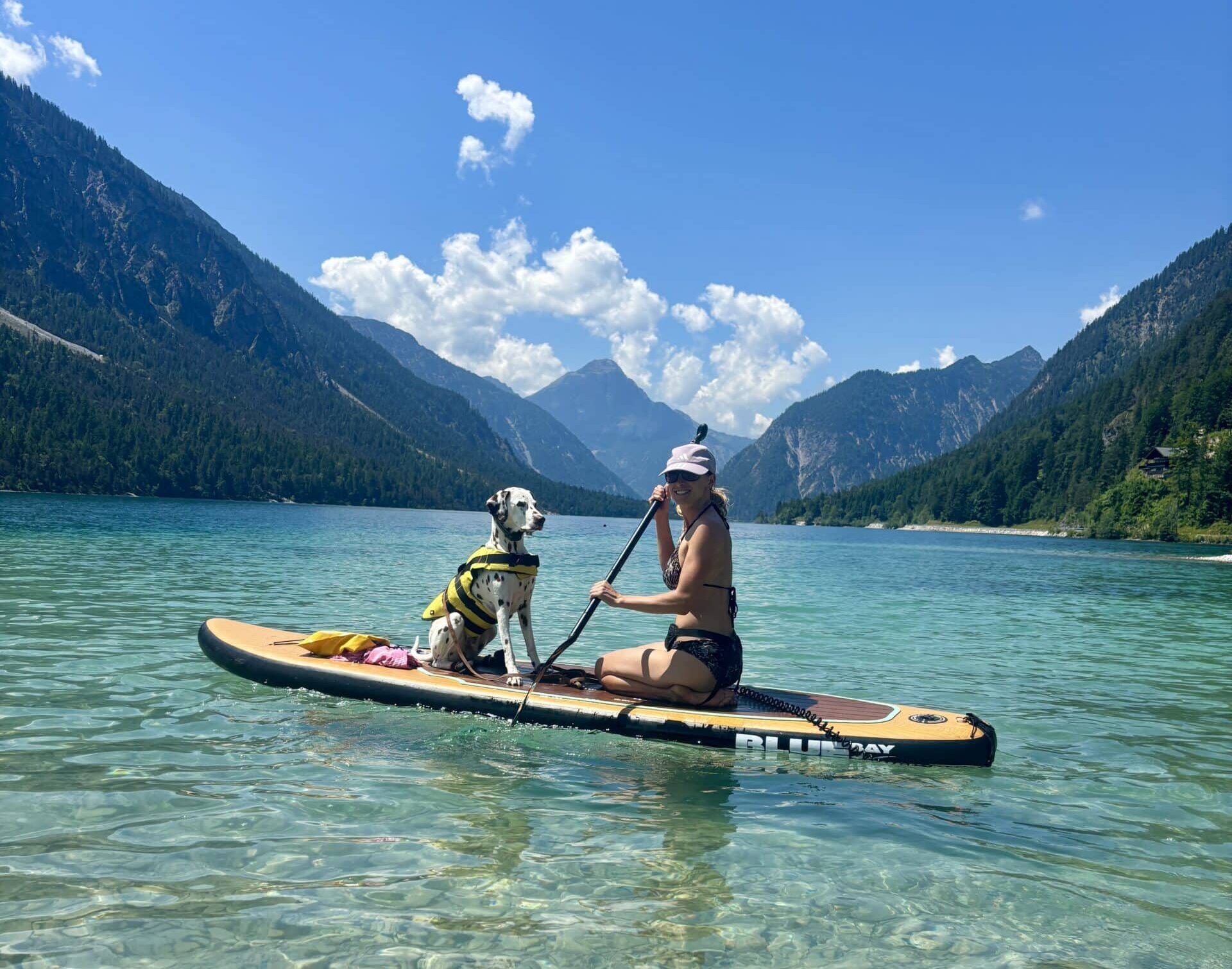 Frau und Hund am SUP am Hundestrand Plansee Tirol Sennalpe