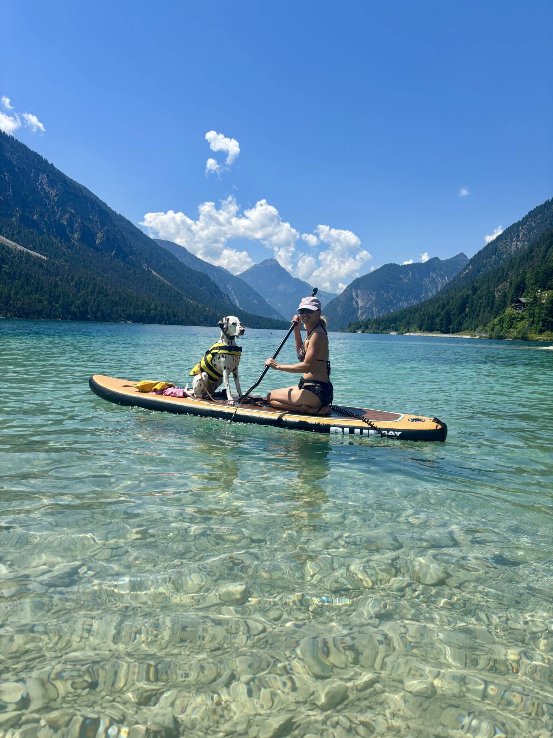 Frau und Hund am SUP am Hundestrand Plansee Tirol Sennalpe