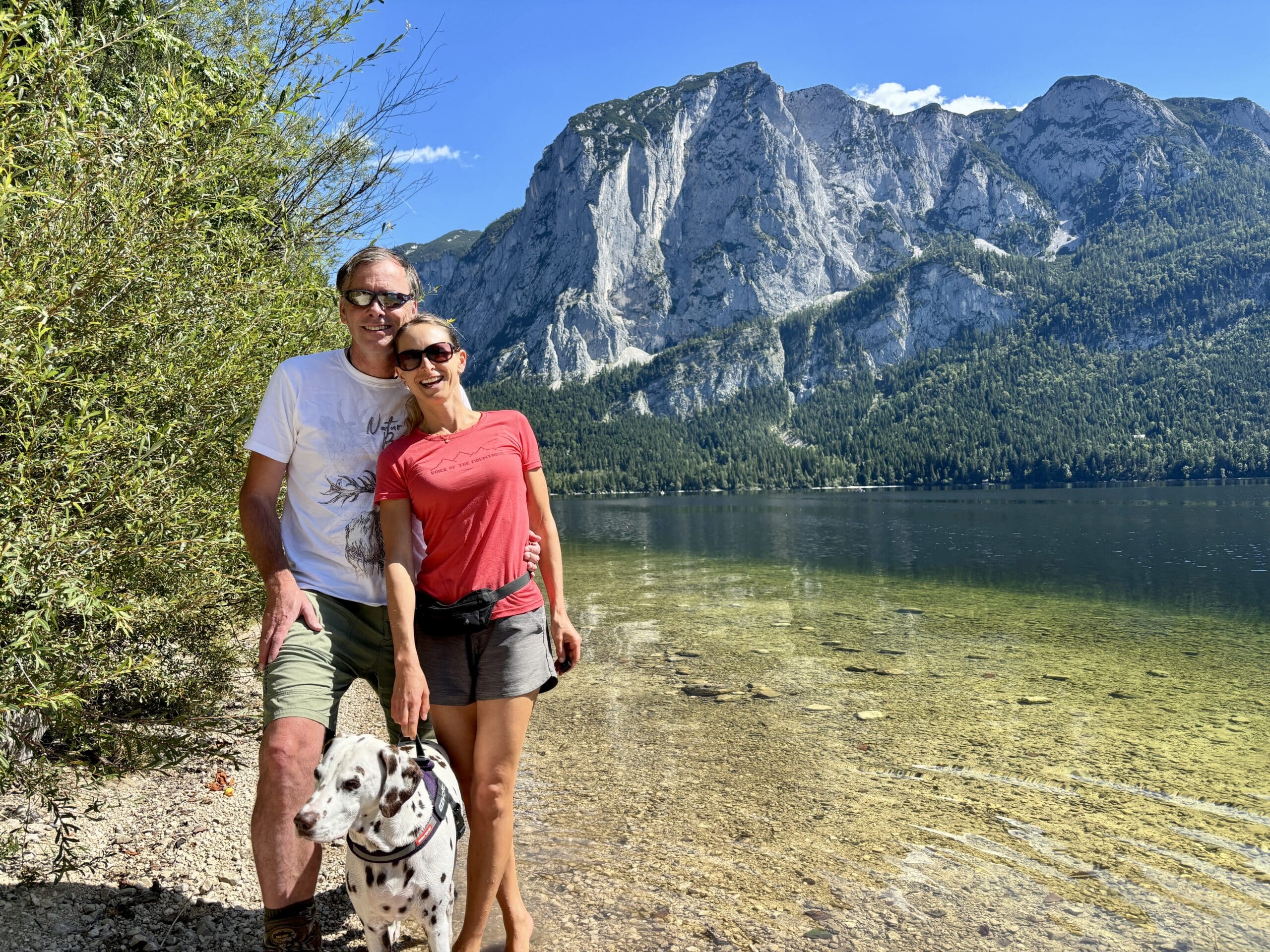 Urlaub mit Hund in Bad Aussee; Pärchen mit Hund stehen am Ufer Altausseer See