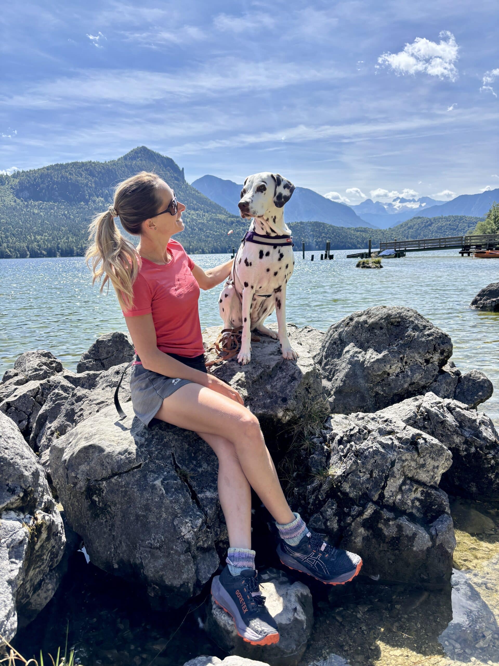 Urlaub mit Hund Ausseerland, Frau sitzt mit Hund auf Felsen am Altausseer See
