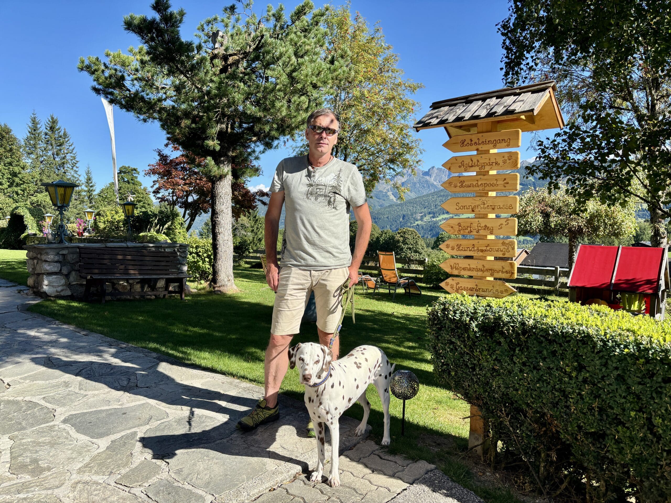 Mann mit Hund im Garten im Hundehotel Almfrieden