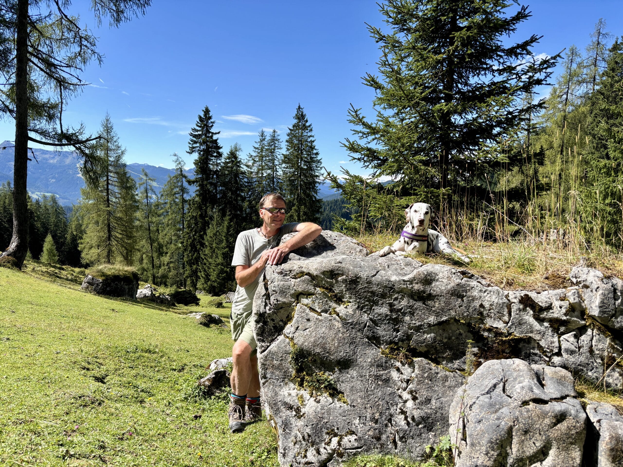 Mann und Hund posieren bei Felsen am Weg zur Lärchbodenalm