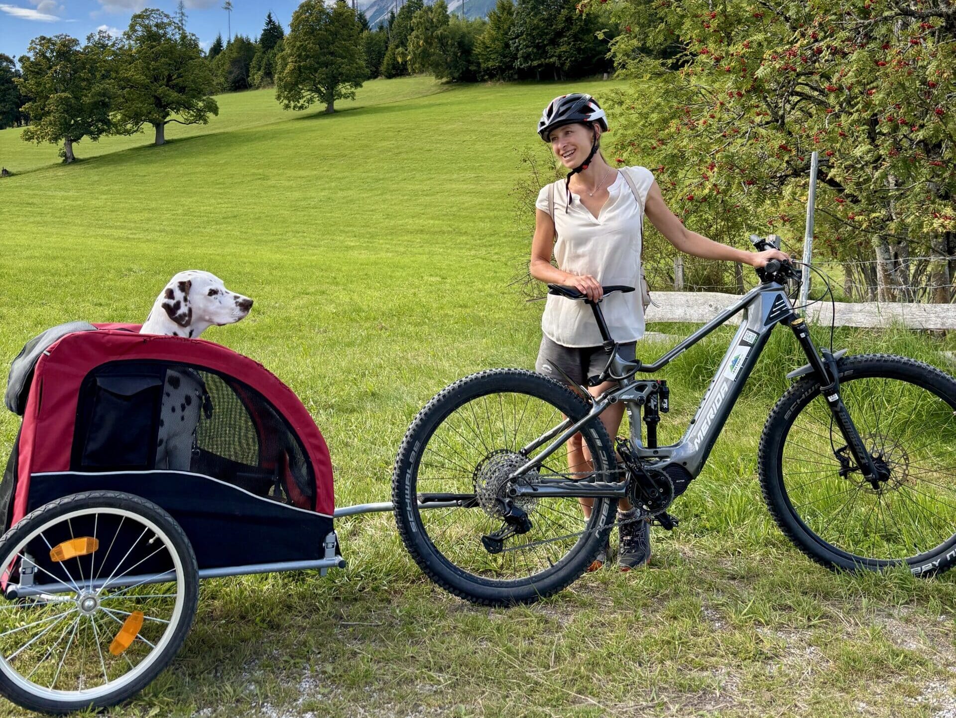 Frau mit E-Bike und Hundefahrradanhänger Hotel Almfrieden