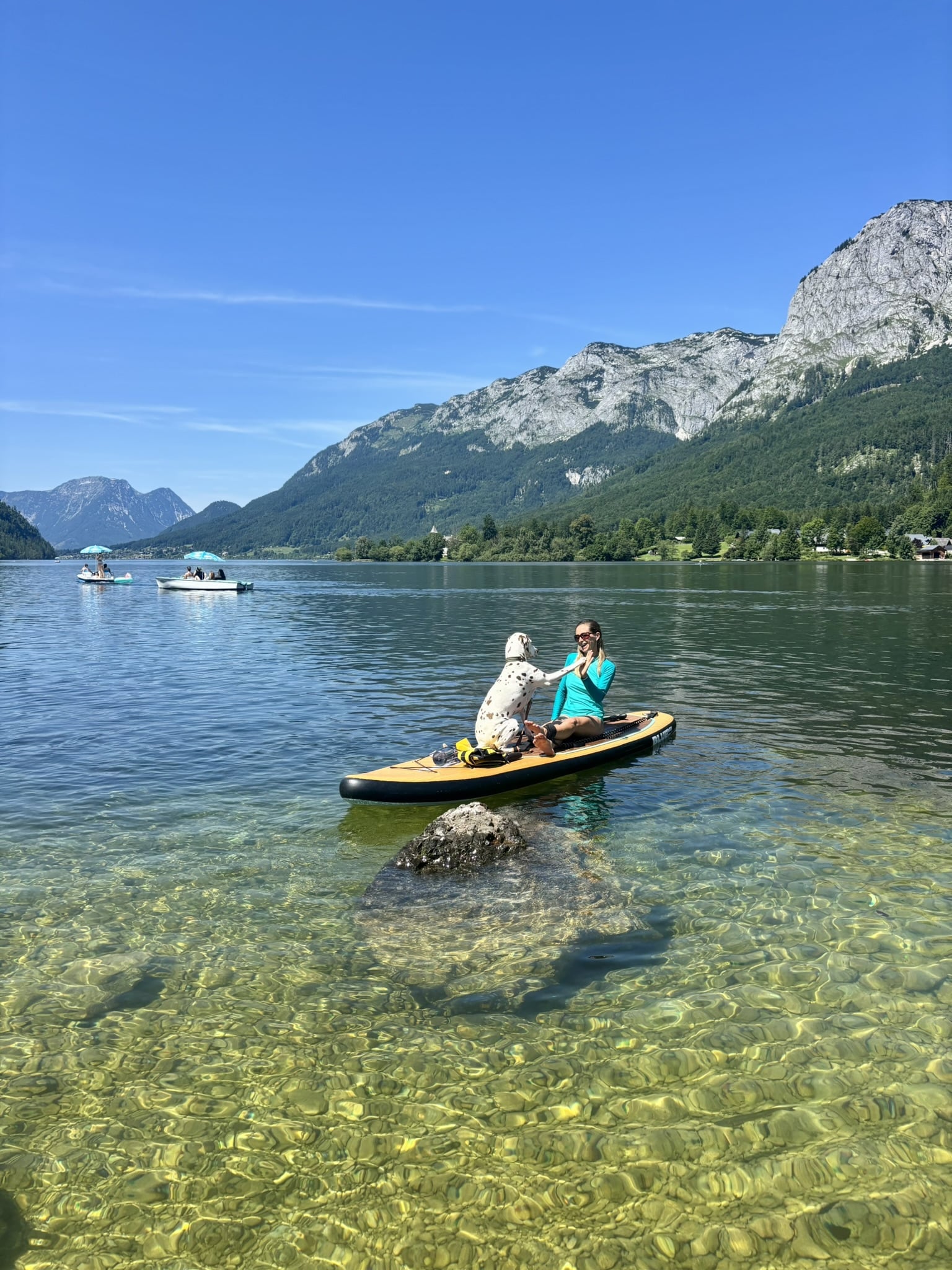 Urlaub mit Hund im Ausseerland, Frau sitzt mit Hund auf SUP im Grundlsee
