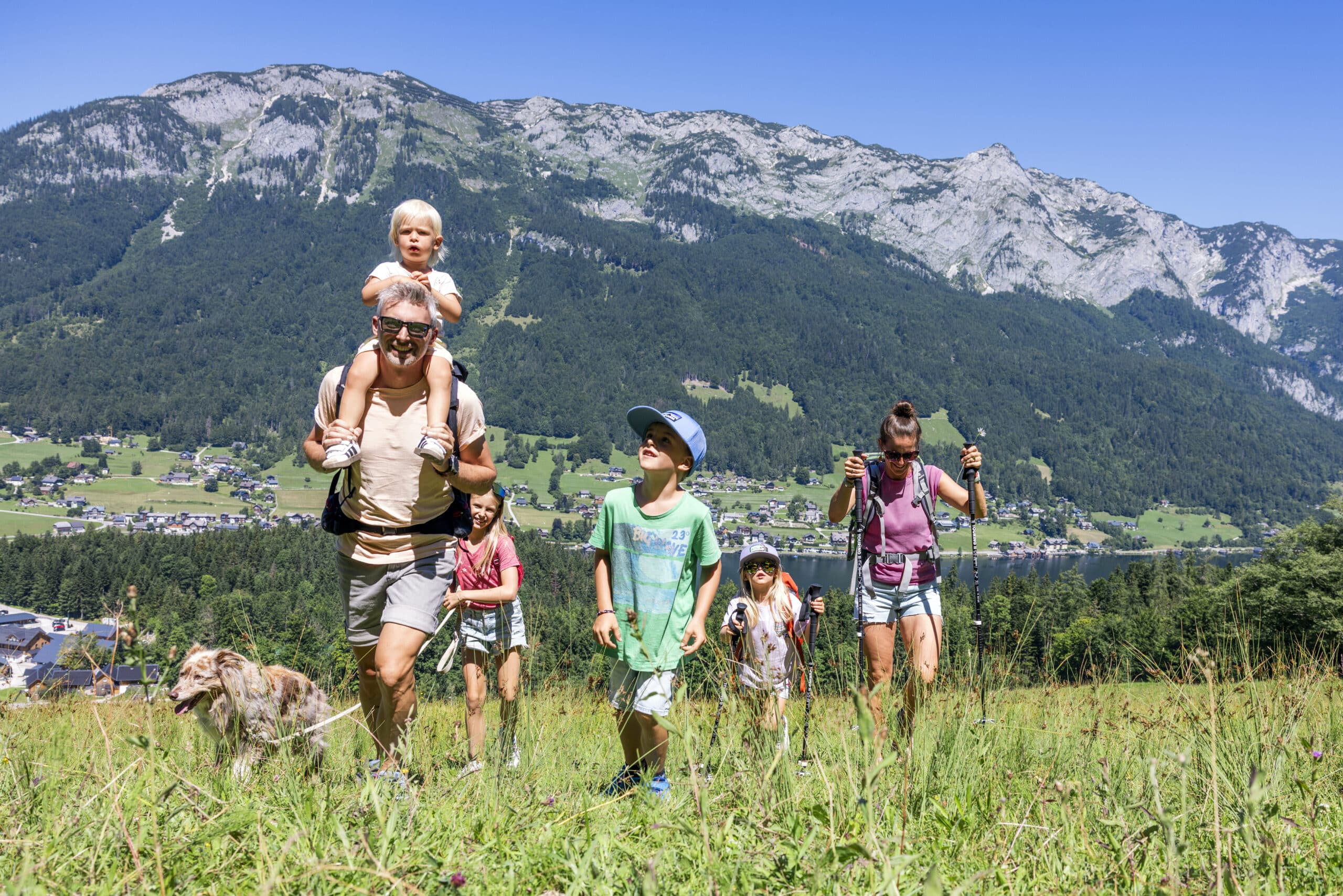 Urlaub und Wandern mit Hund im Narzissendorf Zloam, Familie wandert über Wiese