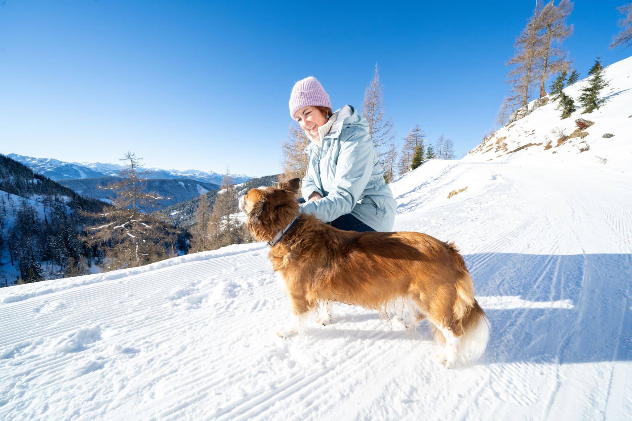 Frau mit Hund im Winter Ramsau am Dachstein
