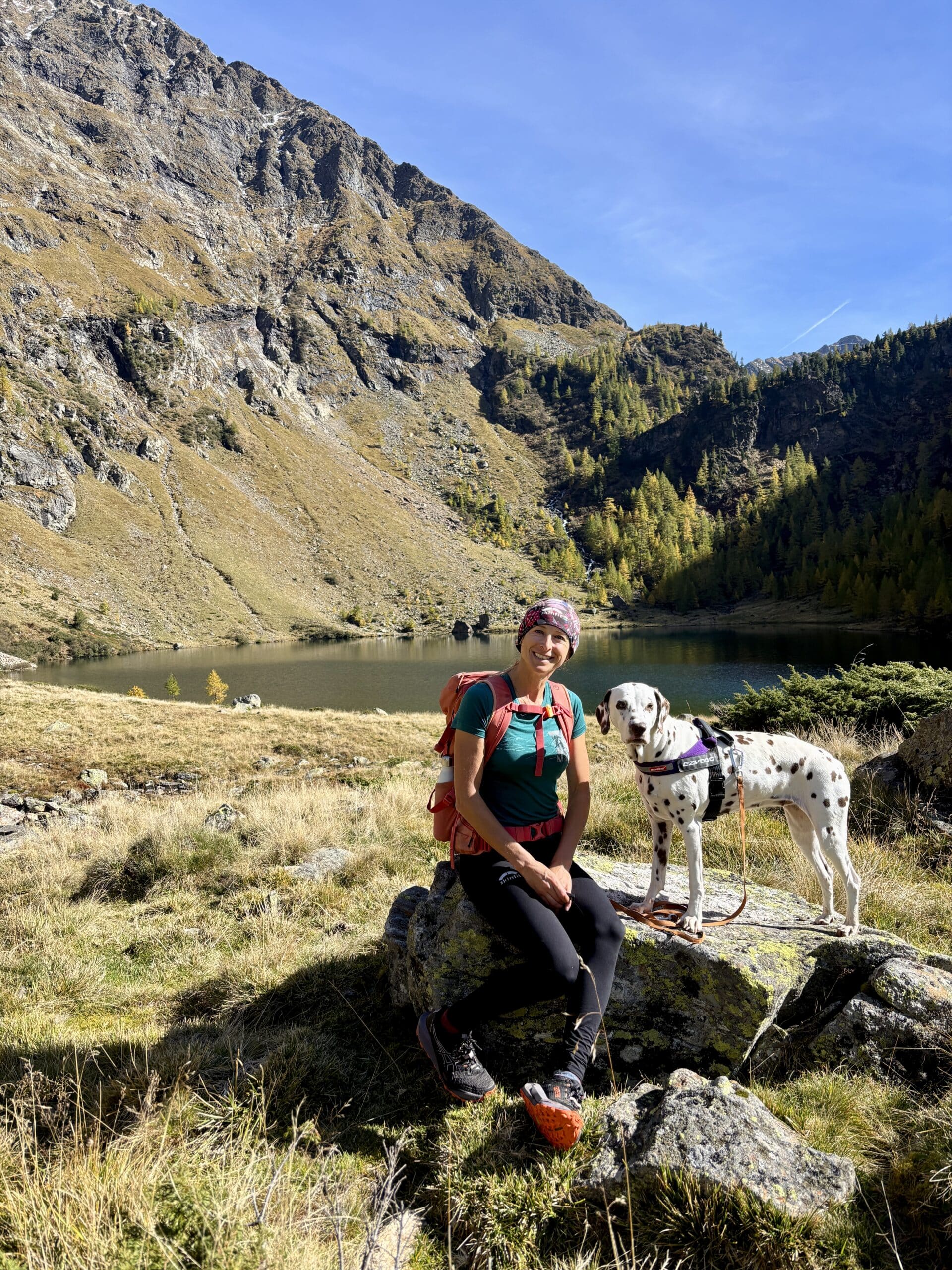 Frau sitzt mit Hund auf Felsen Unterer Landschitzsee
