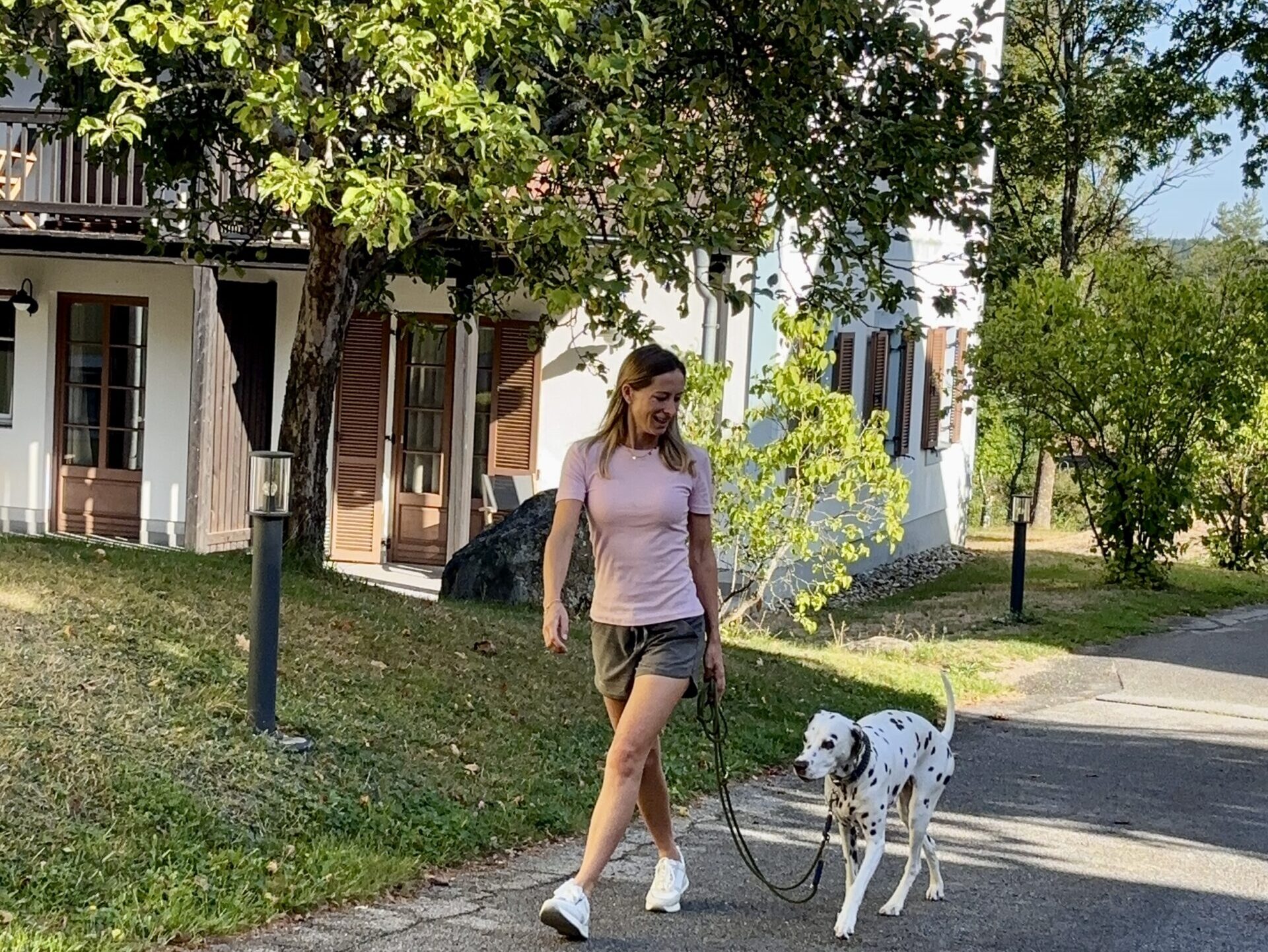 Frau spaziert mit Hund durchs Feriendorf Königsleitn